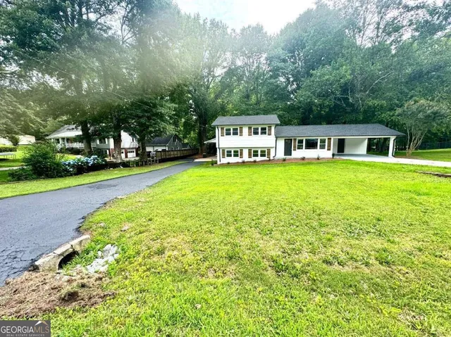 a front view of a house with a garden and yard