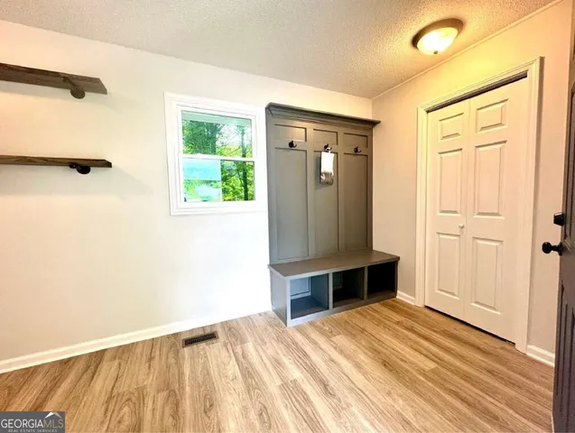 an empty room with wooden floor and windows