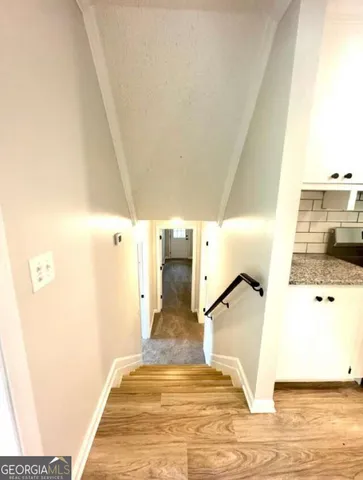 a kitchen with granite countertop a refrigerator and cabinets