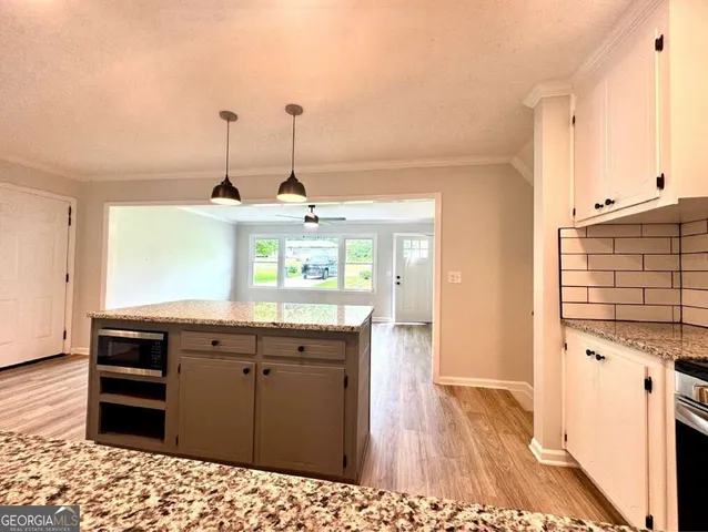 a view of a livingroom with wooden floor and a ceiling fan
