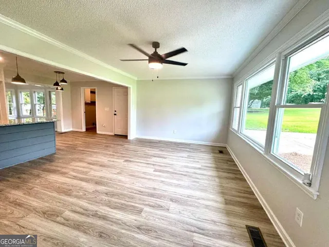 a view of empty room with wooden floor