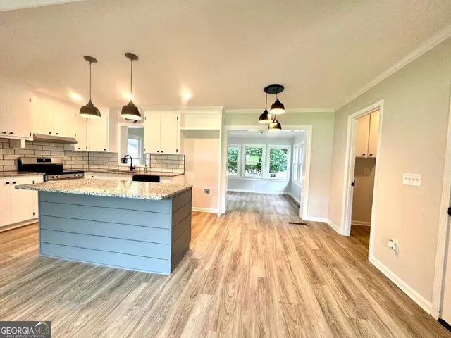 a very nice looking room with a large window and kitchen view