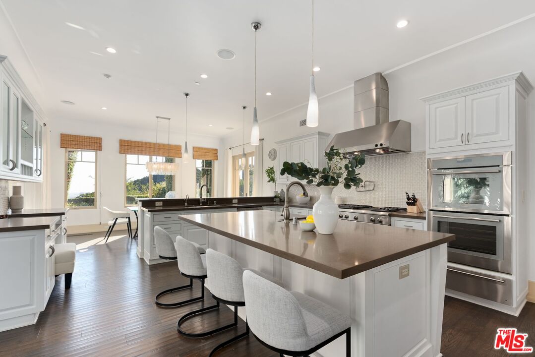 8 Beverly Ridge Terrace Beverly Hills, CA 90210 - Photo 19 of 74 a kitchen with stainless steel appliances granite countertop a sink a stove and a wooden floors
