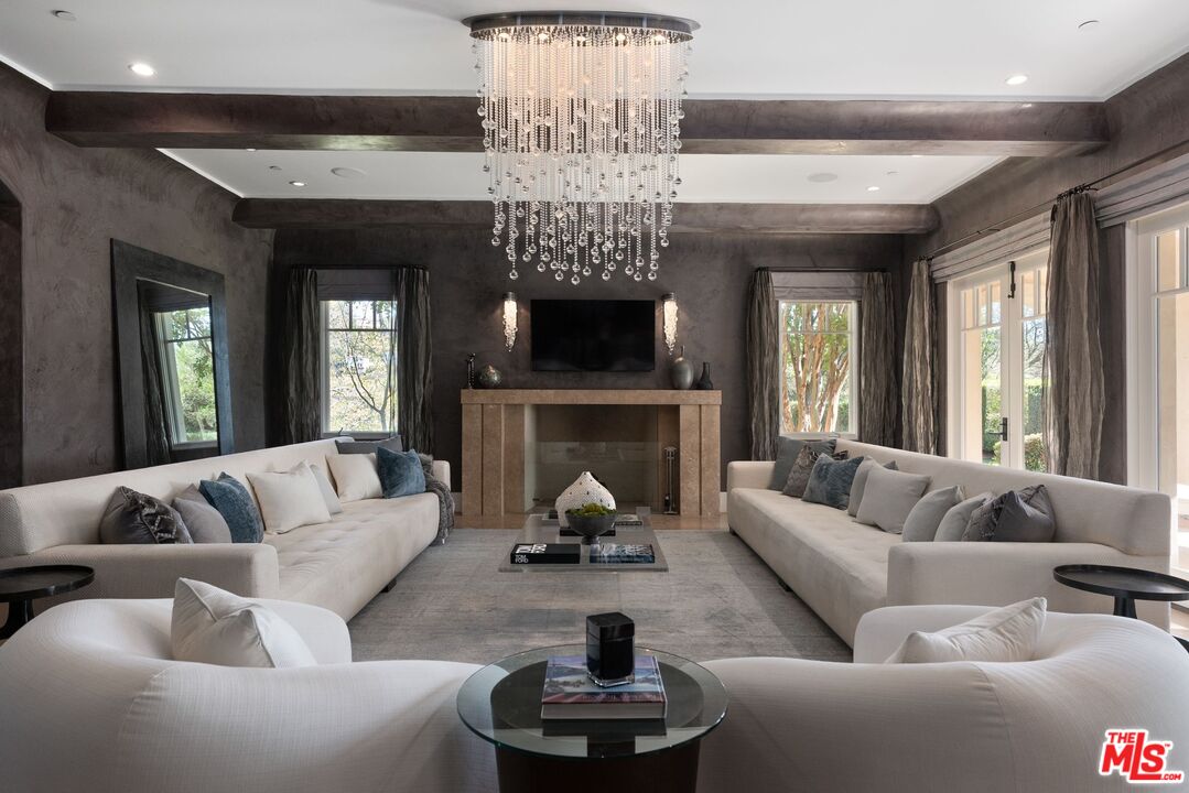 8 Beverly Ridge Terrace Beverly Hills, CA 90210 - Photo 7 of 74 a living room with furniture a fireplace and a chandelier