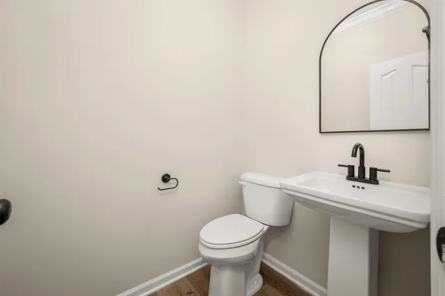 a bathroom with a toilet a sink and mirror