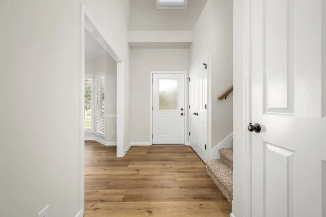 a view of a hallway with wooden floor and staircase