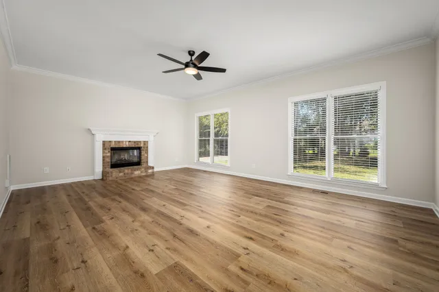 a view of empty room with wooden floor and fireplace