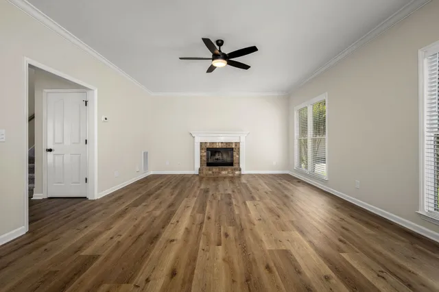 a view of empty room with wooden floor and window