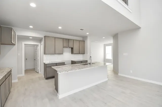 a view of a kitchen with kitchen island and stainless steel appliances