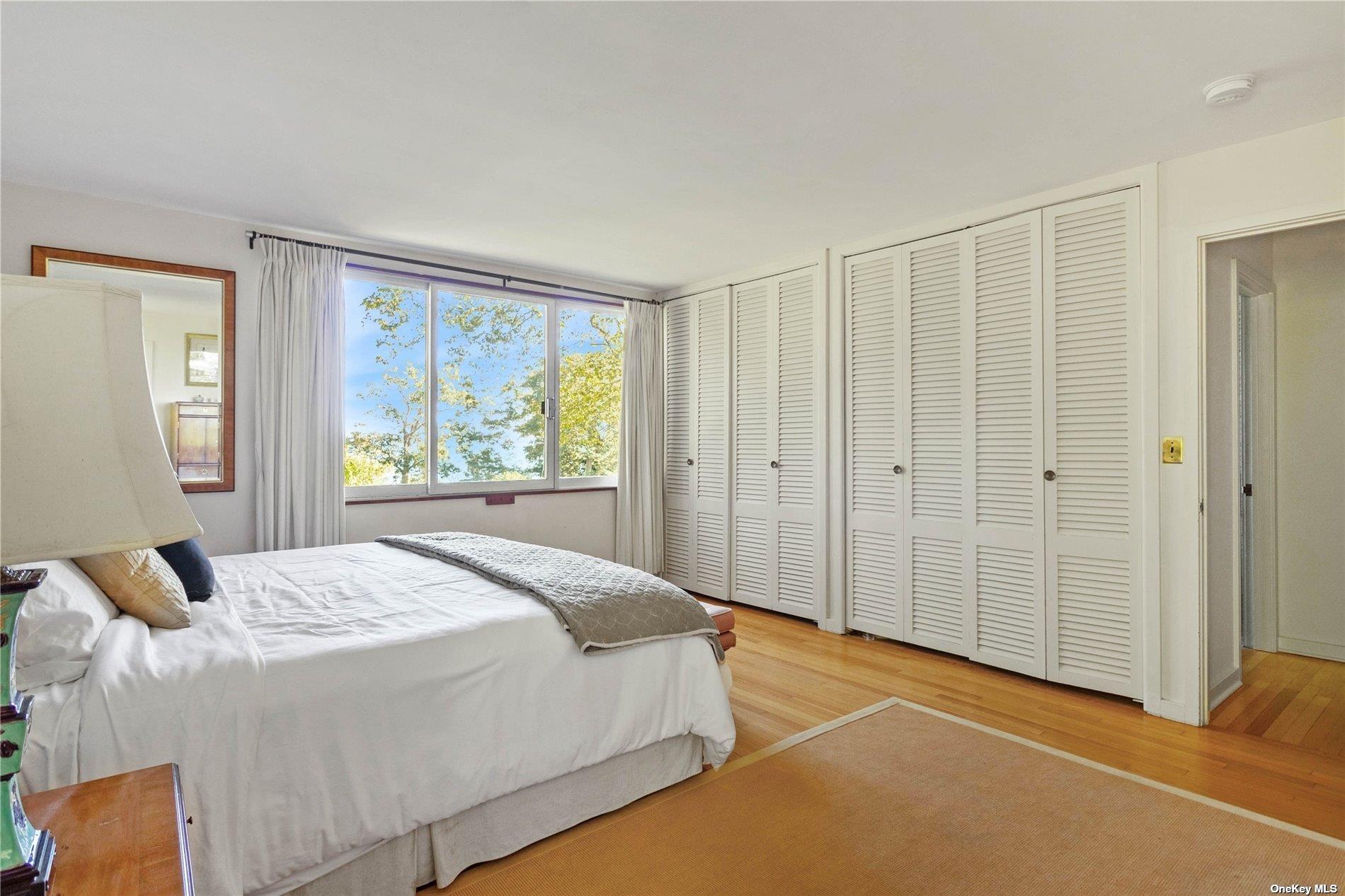 189 Old Harbor Road New Suffolk, NY 11956 - Photo 18 of 26 a spacious bedroom with a bed and a window