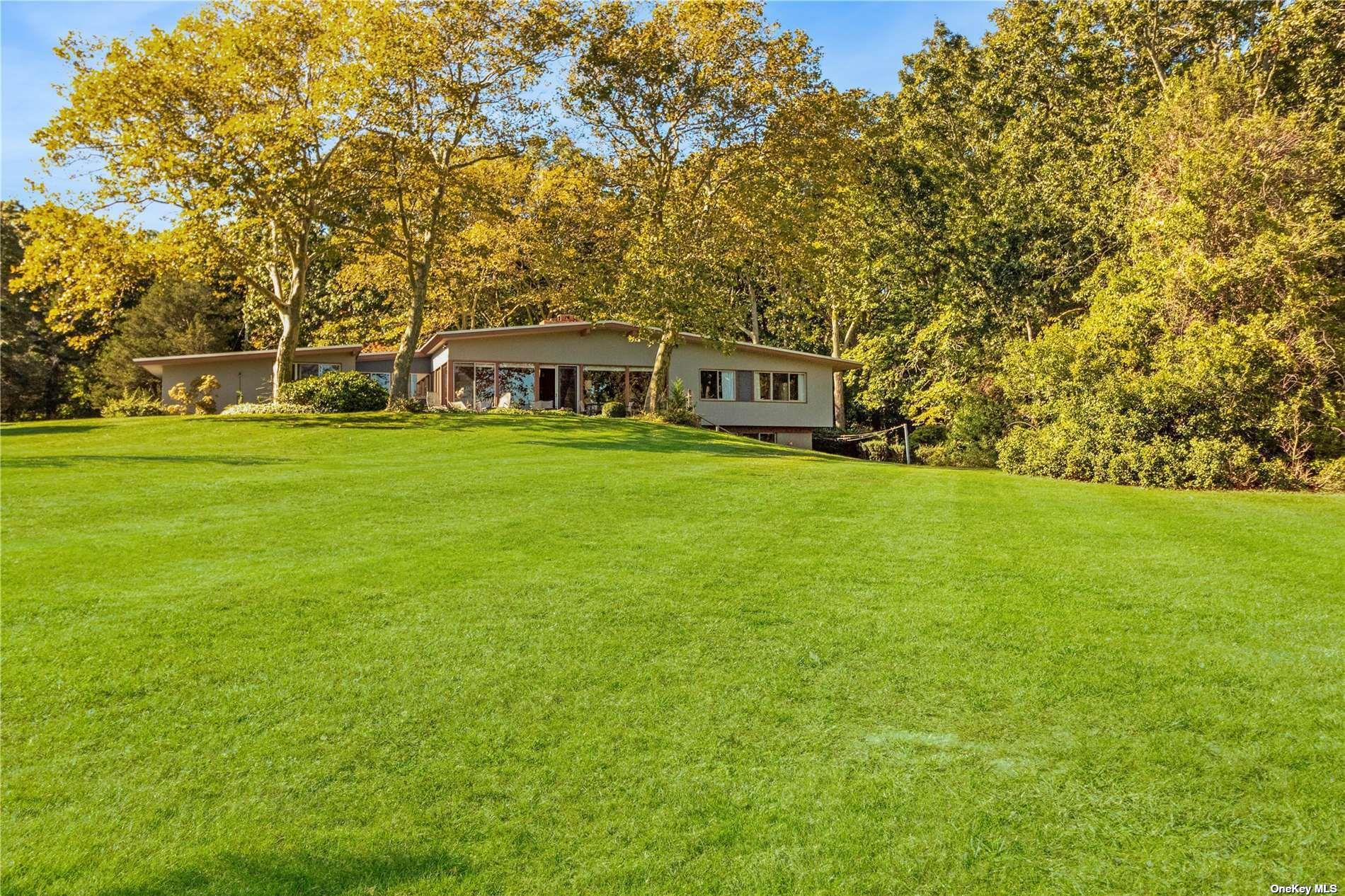 189 Old Harbor Road New Suffolk, NY 11956 - Photo 19 of 26 a front view of a house with a garden