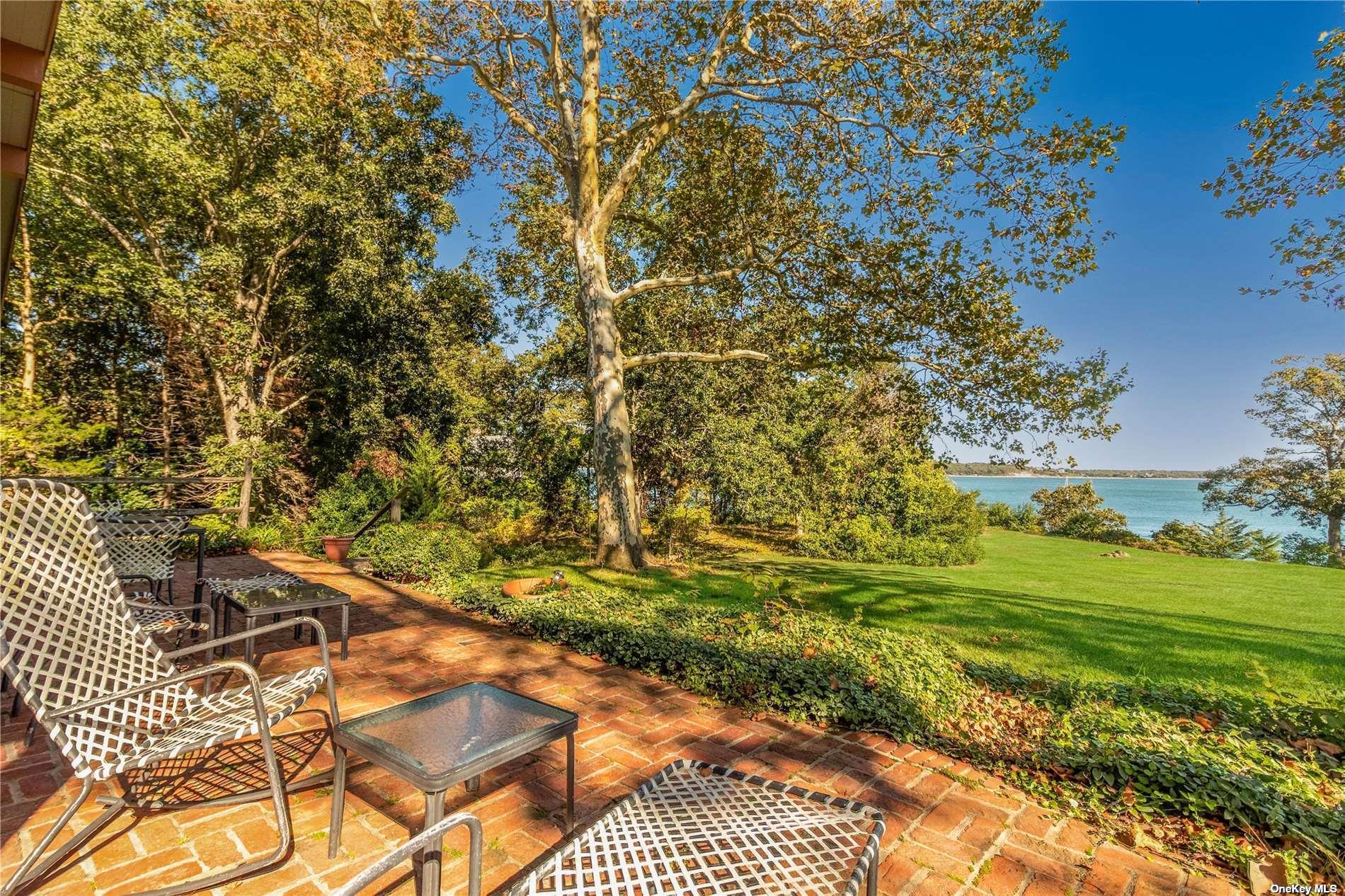 189 Old Harbor Road New Suffolk, NY 11956 - Photo 20 of 26 a backyard of a house with a yard and outdoor seating