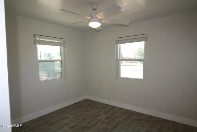 an empty room with a window and a fan