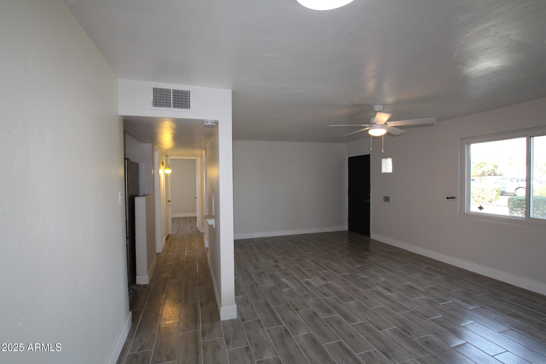 1333 East Flower Street Phoenix, AZ 85014 - Photo 7 of 20 an empty room with wooden floor and a window