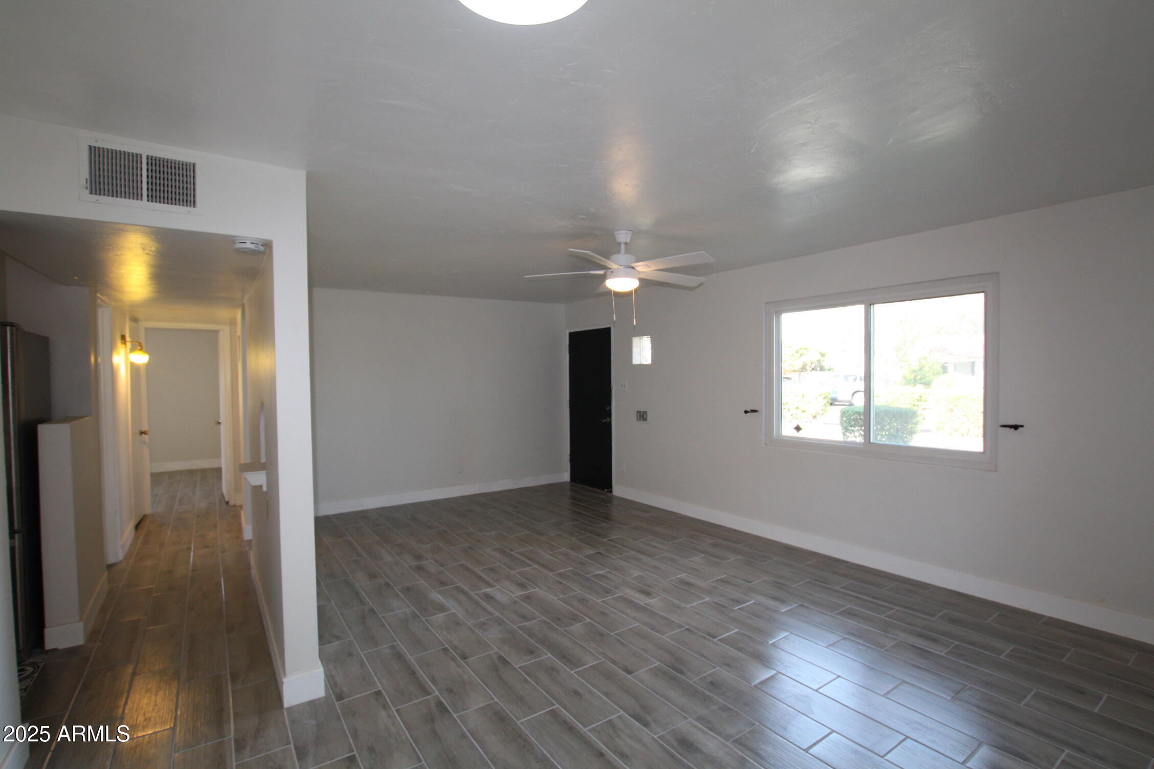 1333 East Flower Street Phoenix, AZ 85014 - Photo 8 of 20 an empty room with wooden floor and a window