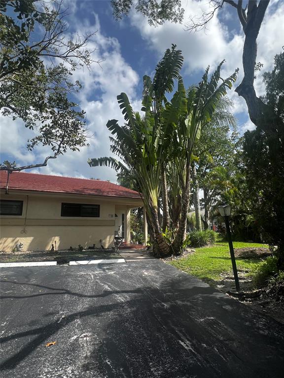 718 Southwest 88th Terrace, Unit 718 Plantation, FL 33324 - Photo 2 of 37 a front view of a house with a yard