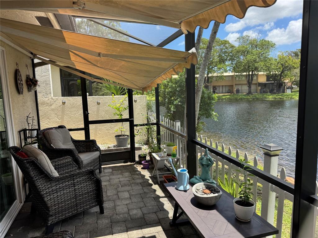 718 Southwest 88th Terrace, Unit 718 Plantation, FL 33324 - Photo 27 of 37 a balcony with wooden floor table and chairs