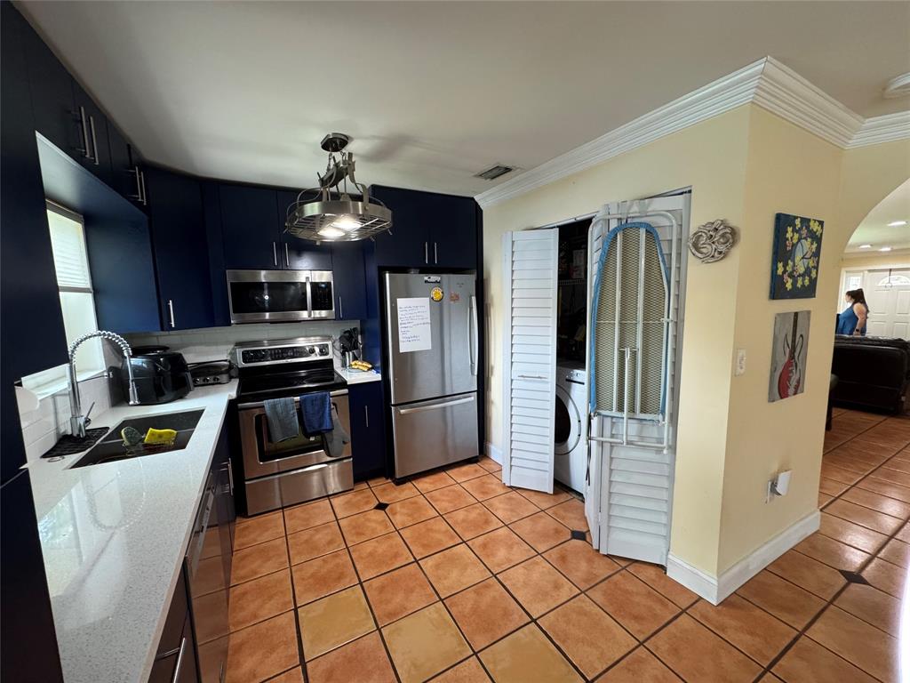 718 Southwest 88th Terrace, Unit 718 Plantation, FL 33324 - Photo 5 of 37 a kitchen with granite countertop a refrigerator and a stove top oven