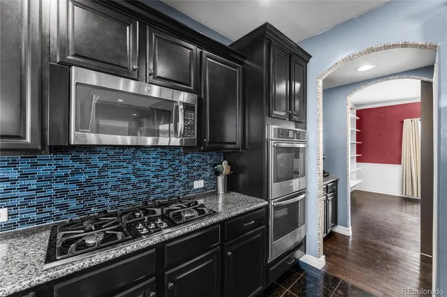 a kitchen with granite countertop stainless steel appliances and wooden cabinets