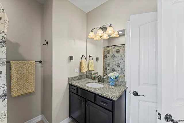 a bathroom with a granite countertop sink a mirror and a shower