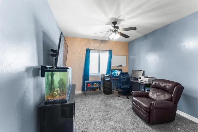 a living room with furniture a ceiling fan and a window