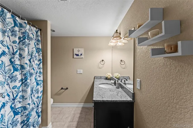 a bathroom with a granite countertop sink and a mirror