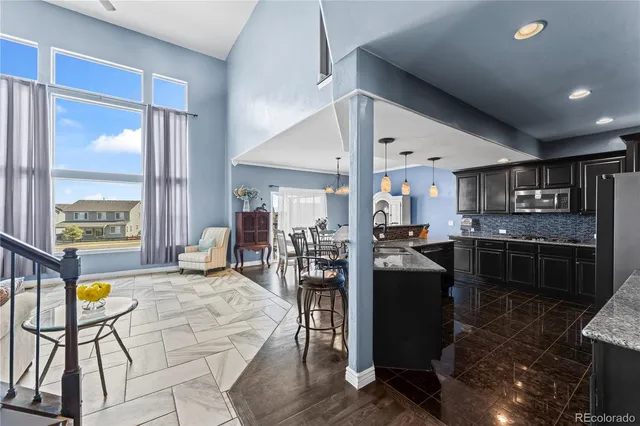 a living room with stainless steel appliances kitchen island granite countertop furniture and a kitchen view