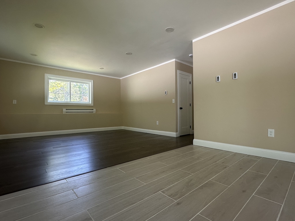 102 Wells Road Becket, MA 01223 - Photo 23 of 40 an empty room with wooden floor and windows