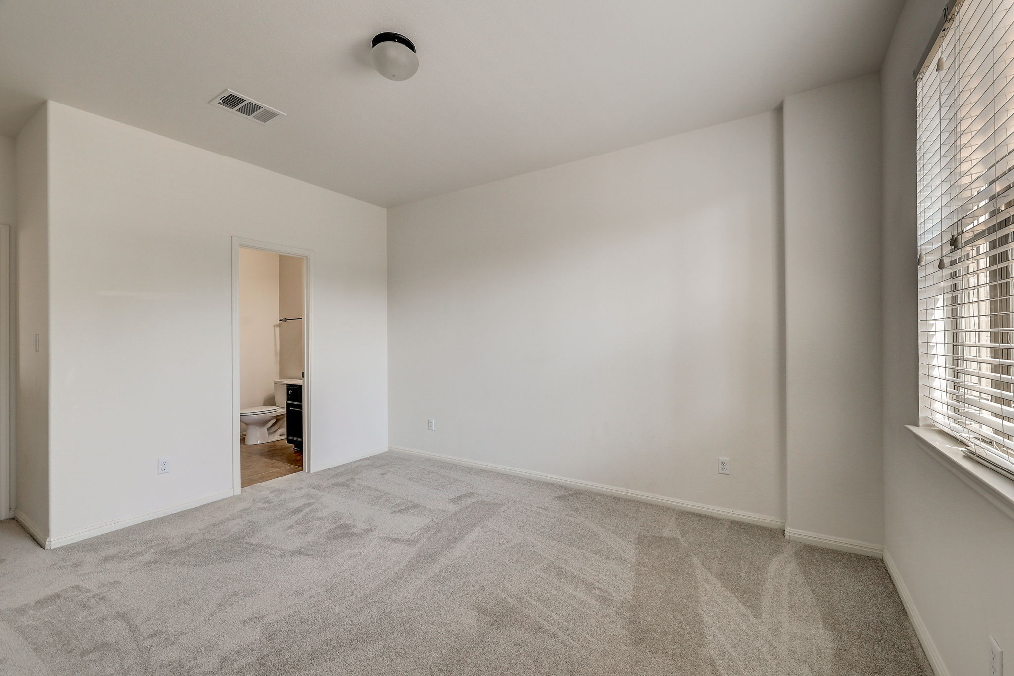 16012 Spillman Ranch Loop Austin, TX 78738 - Photo 29 of 38 A spacious, naturally illuminated room featuring plush carpeting and a private en-suite bathroom.