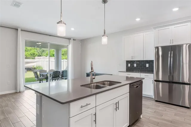 a kitchen with stainless steel appliances granite countertop a refrigerator and a sink