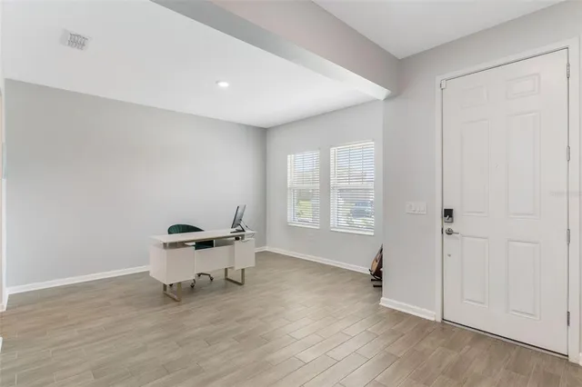 a view of a workspace with furniture and wooden floor