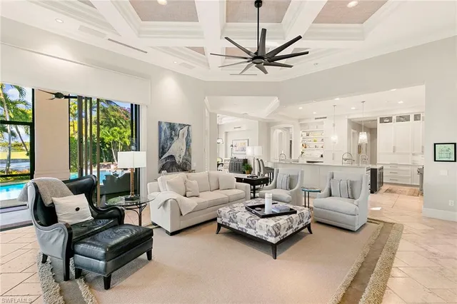 a living room with furniture ceiling fan and a large window
