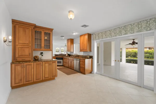 a large kitchen with kitchen island a large counter top space a sink stainless steel appliances and cabinets