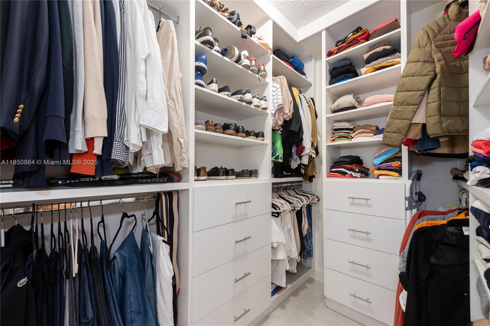 520 Brickell Key Drive, Unit A1102 Miami, FL 33131 - Photo 18 of 33 a view of walk in closet with clothes and shoes