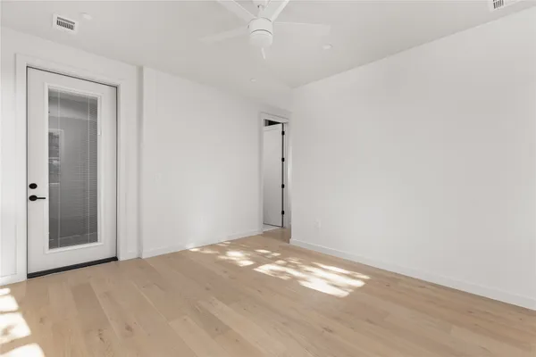 a view of empty room with wooden floor