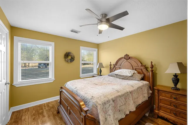 a bedroom with a bed and a dresser next to a window