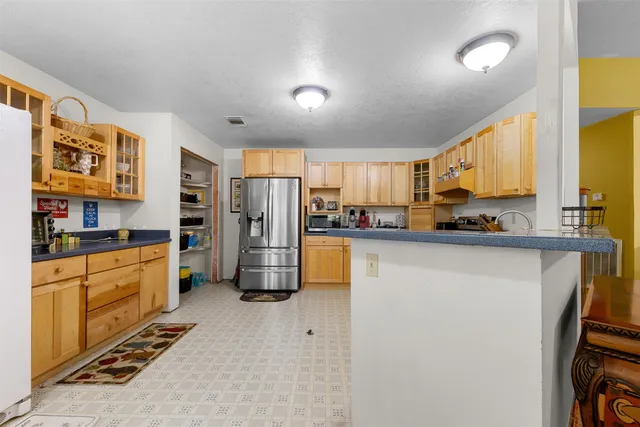 a kitchen with stainless steel appliances a refrigerator a sink and white cabinets