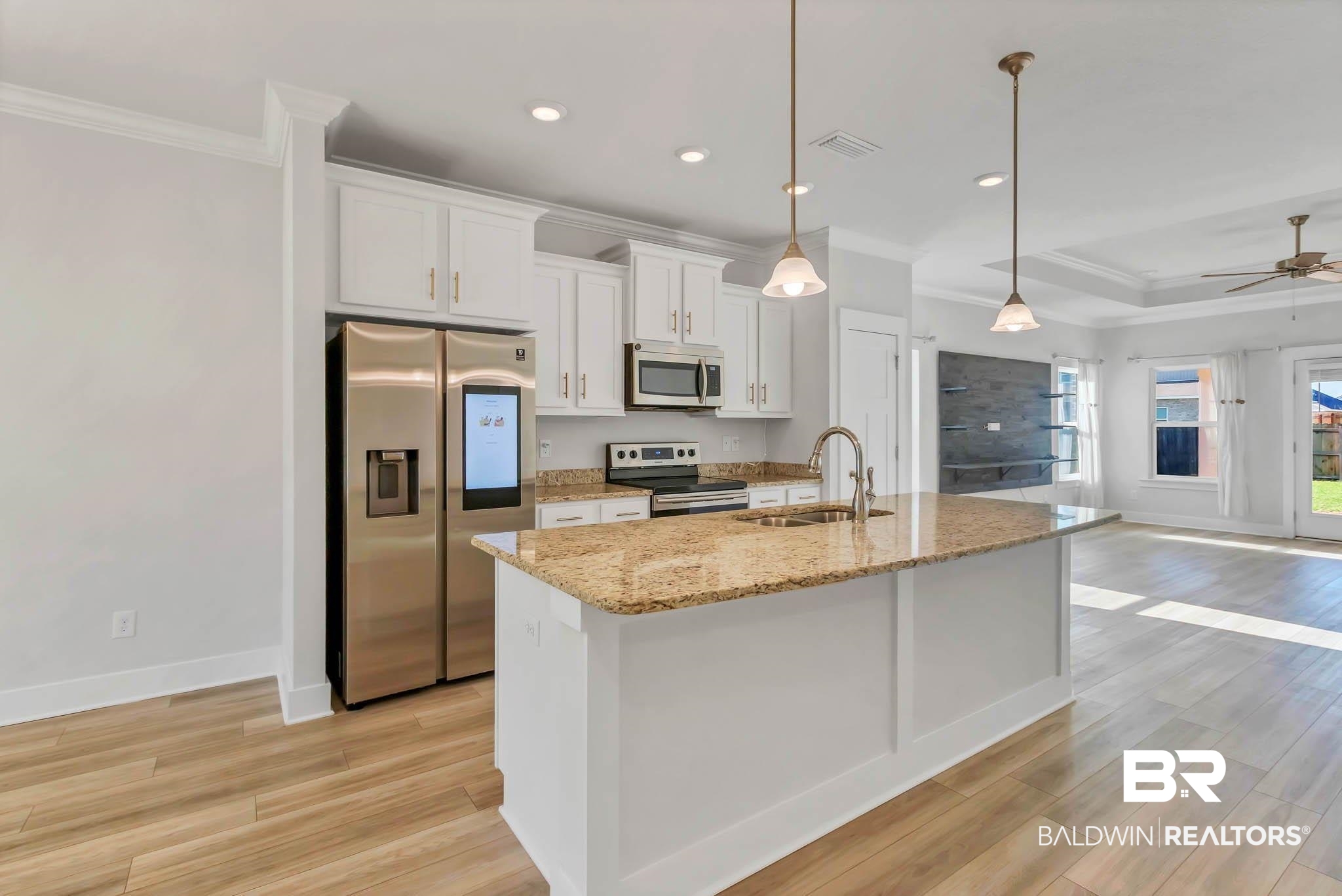 16461 Prado Loop Loxley, AL 36551 - Photo 11 of 78 Kitchen featuring crown molding, stainless steel appliances, white cabinetry, decorative light fixtures, and light stone countertops