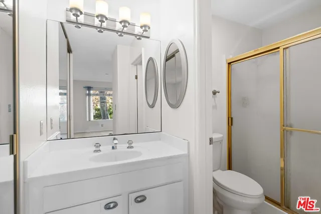 a bathroom with a granite countertop sink toilet and shower