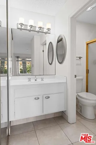 a bathroom with a toilet a sink and a mirror