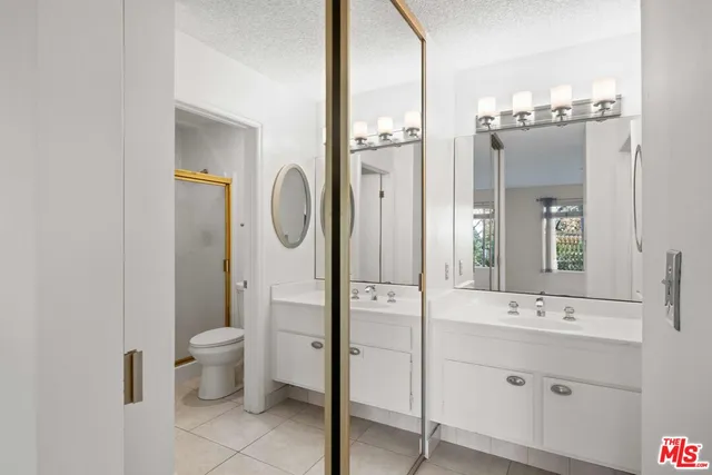 a bathroom with a double vanity sink mirror and toilet