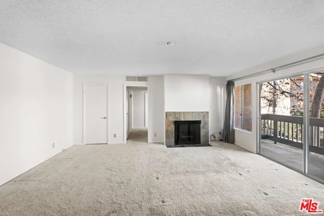 a view of an empty room with a fireplace