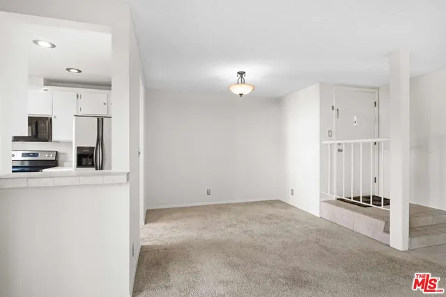 a view of kitchen with furniture and refrigerator