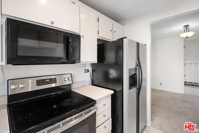 a kitchen with stainless steel appliances a stove a microwave and a refrigerator