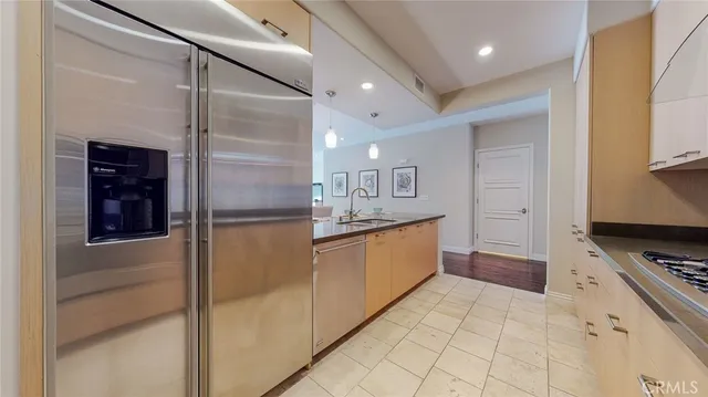 a large kitchen with stainless steel appliances kitchen island granite countertop a refrigerator and a stove top oven