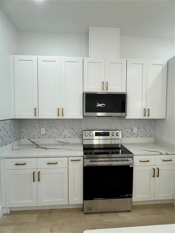 1721 McClellan Road Frostproof, FL 33843 - Photo 4 of 41 a kitchen with granite countertop white cabinets and stainless steel appliances
