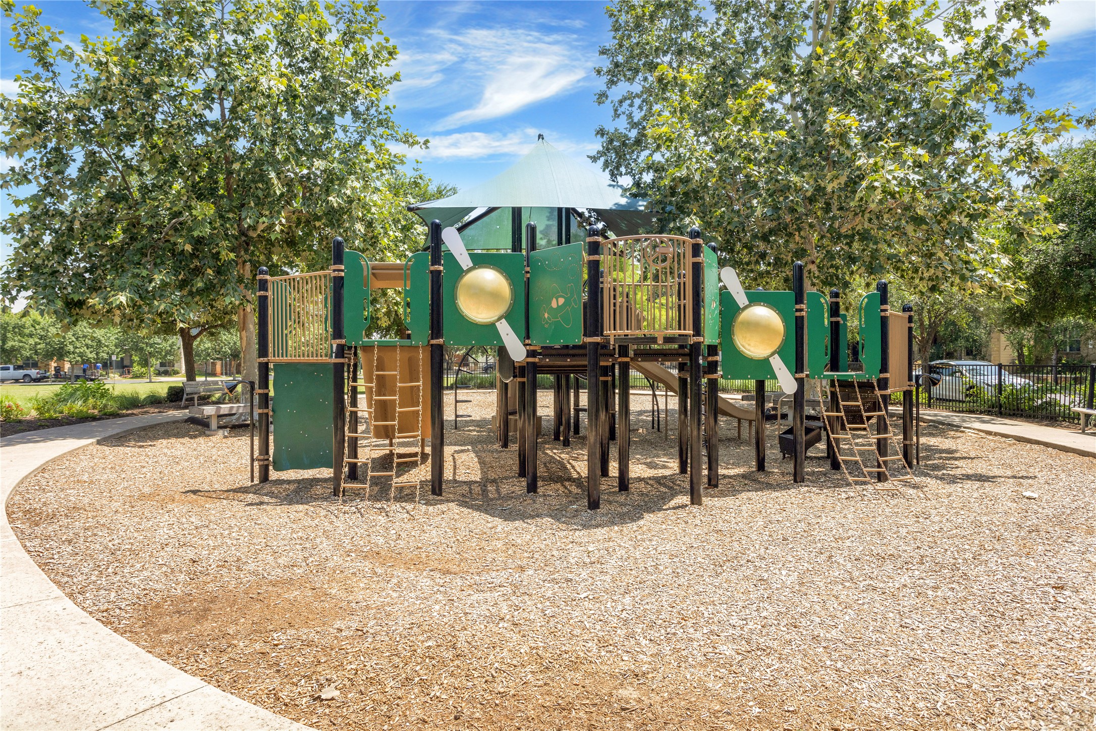 2805 McCurdy Street, Unit 14 Austin, TX 78723 - Photo 29 of 40 A well-maintained community playground awaits, featuring varied play structures over soft wood chips.