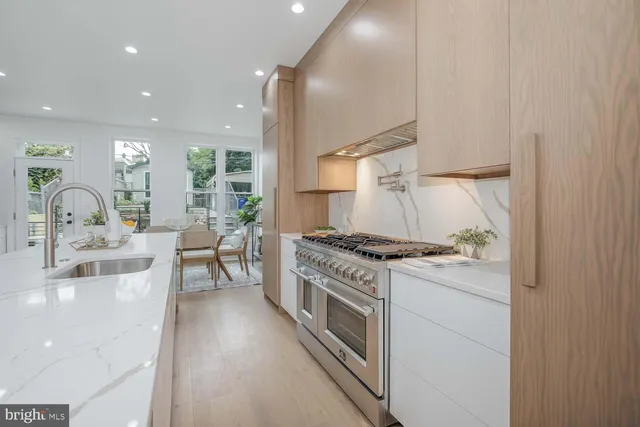a kitchen with stainless steel appliances kitchen island granite countertop a refrigerator and a sink