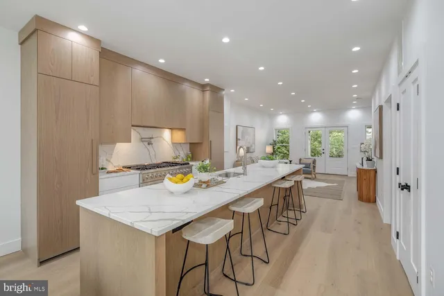 a kitchen with a table chairs wooden floor and a view of kitchen
