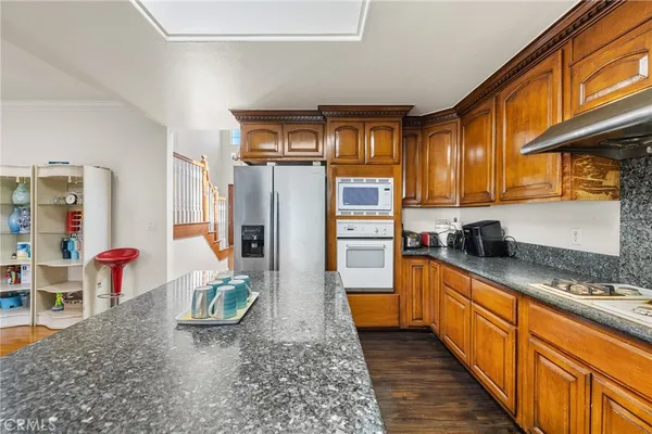 a kitchen with stainless steel appliances granite countertop a sink a stove counter space and cabinets